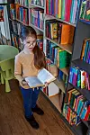 Child girl choosing book in school library. School education. Be