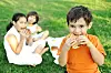 Small group of children in nature eating snacks together, sandwiches, bread